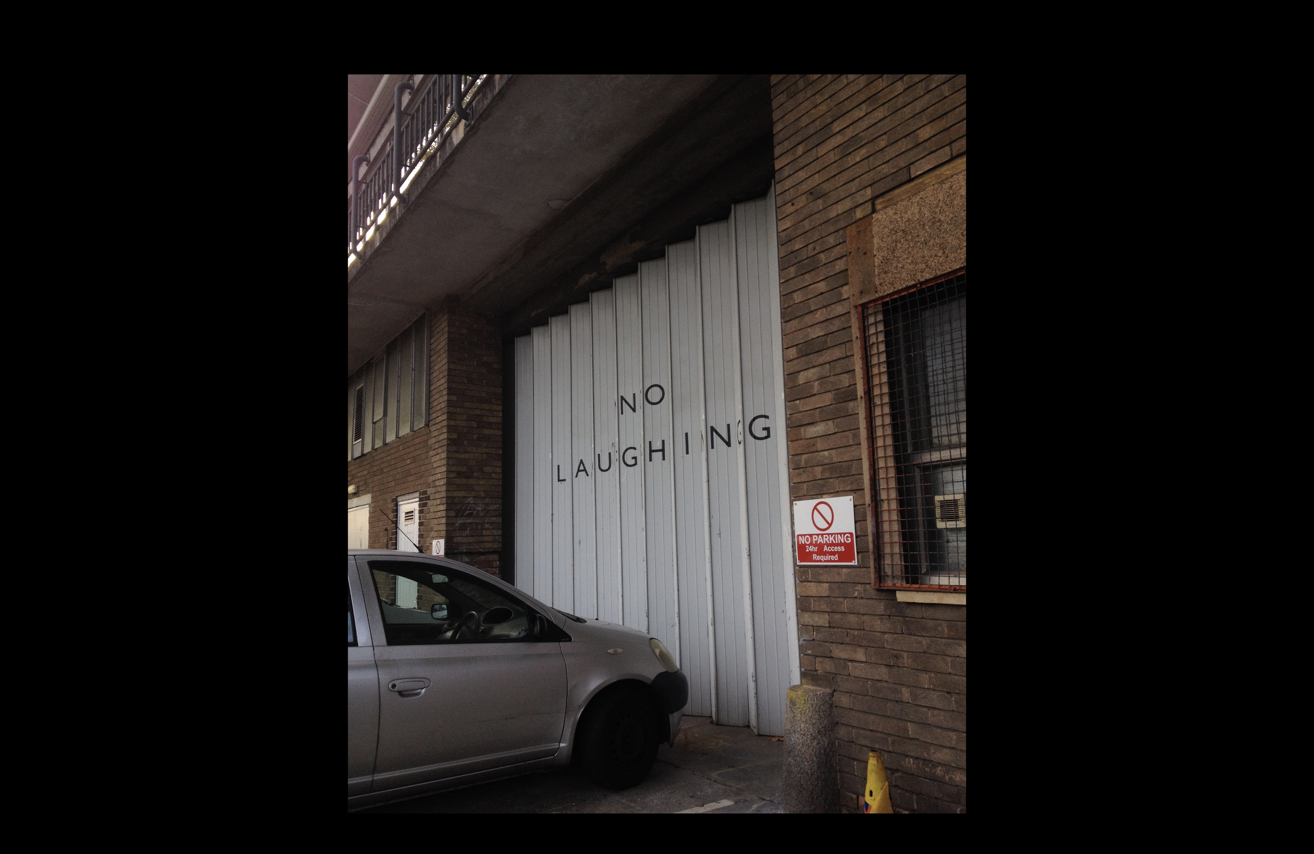 A vertically folding garage door at Spike Island spelling out